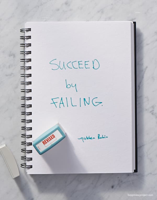 White notebook with "Succeed by Failing" written.