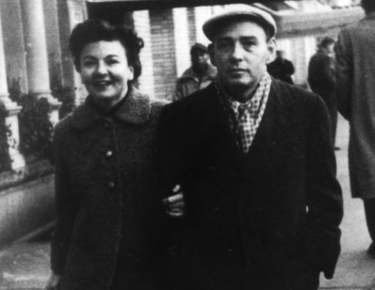Black and white photo of a man and woman walking side by side.