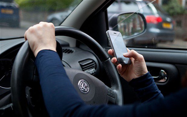 Image of someone texting and driving.