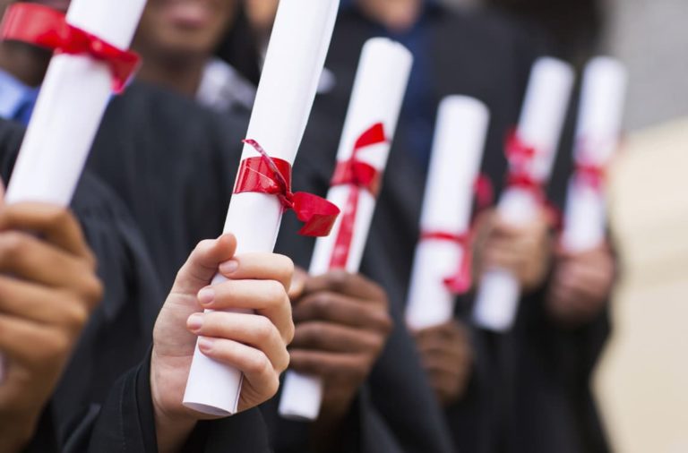 graduating students holding diplomas