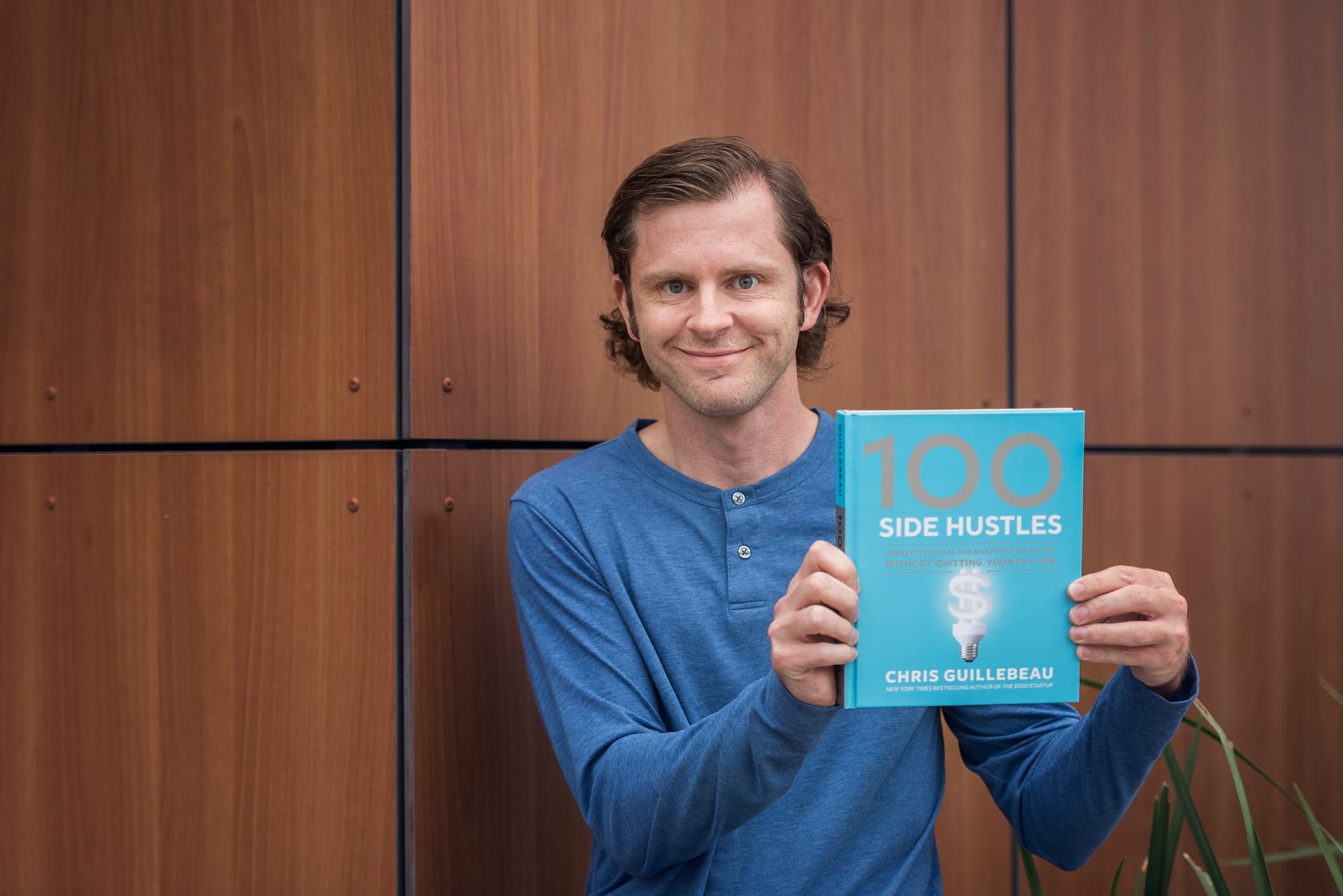 Chris Guillebeau with his book 100 Side Hustles