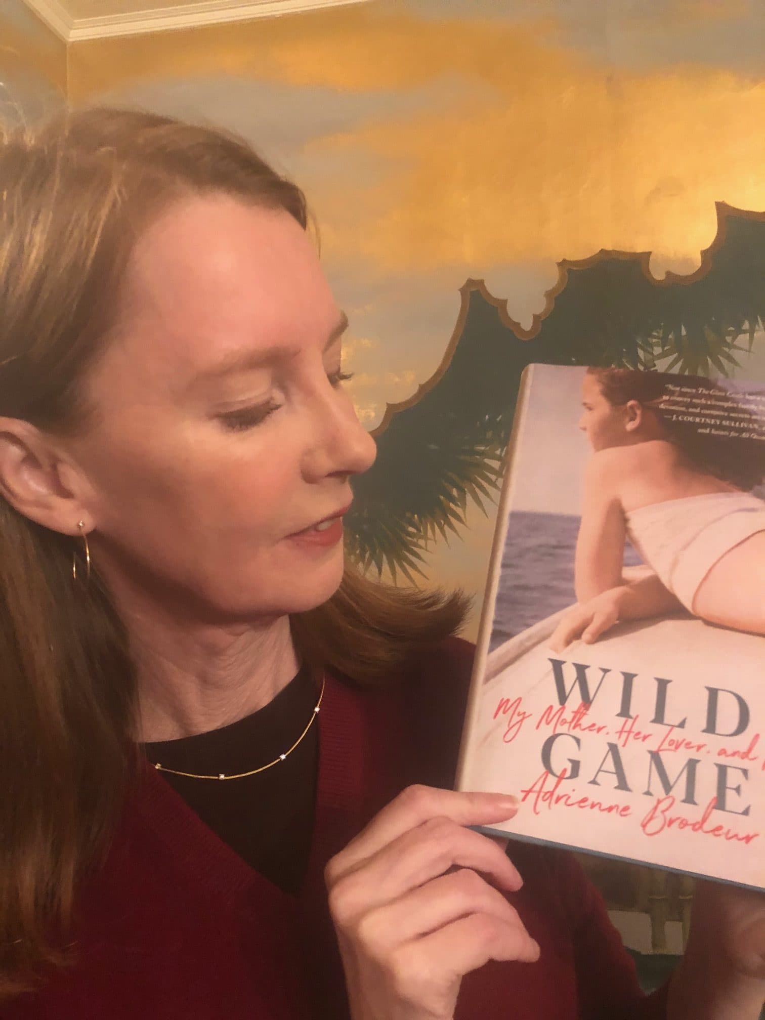 Gretchen holding the book Wild Game by Adrienne Brodeur