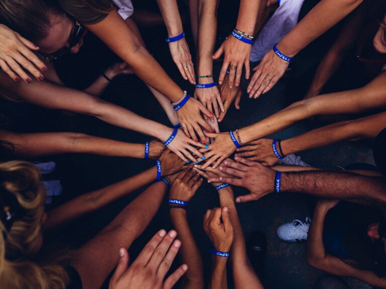 Picture of people putting hands into the middle of a circle