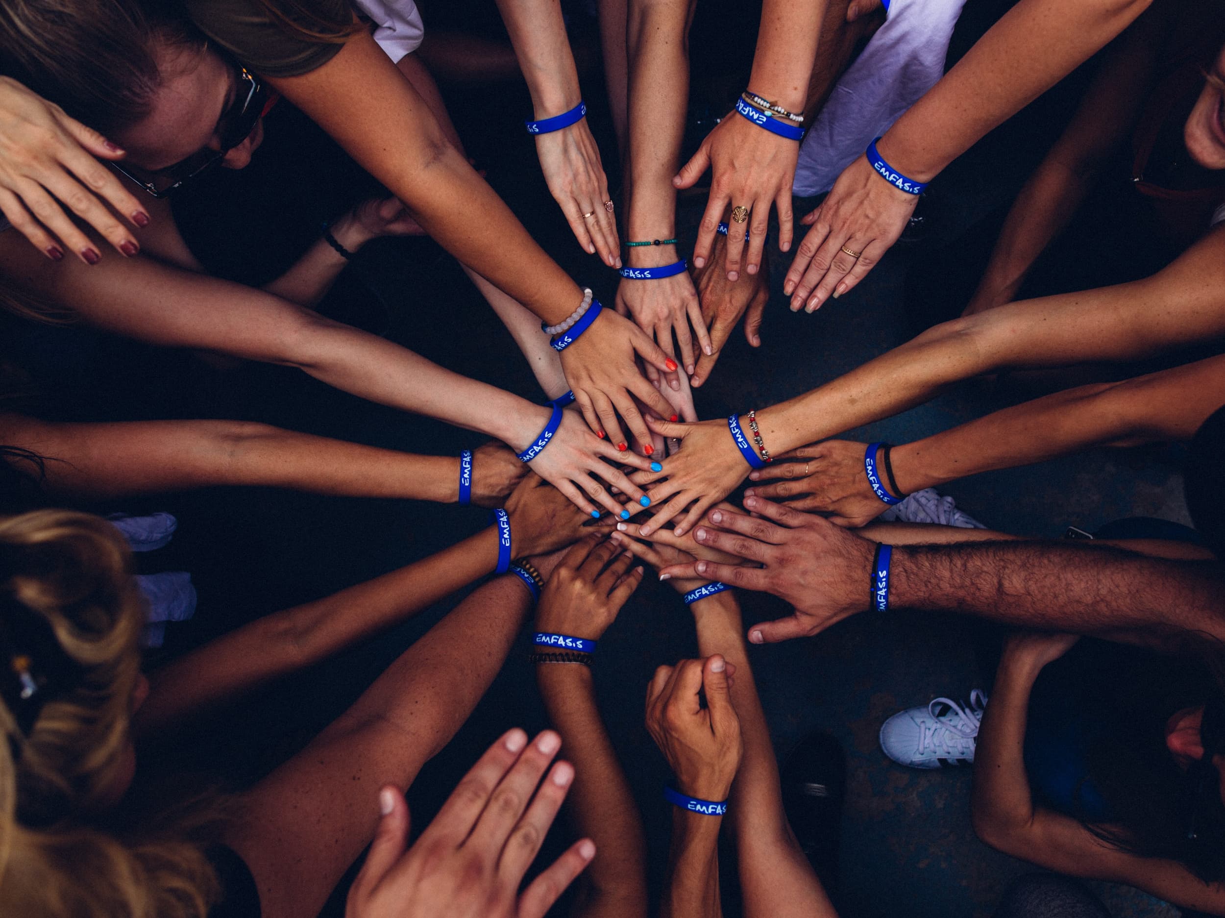 Picture of people putting hands into the middle of a circle
