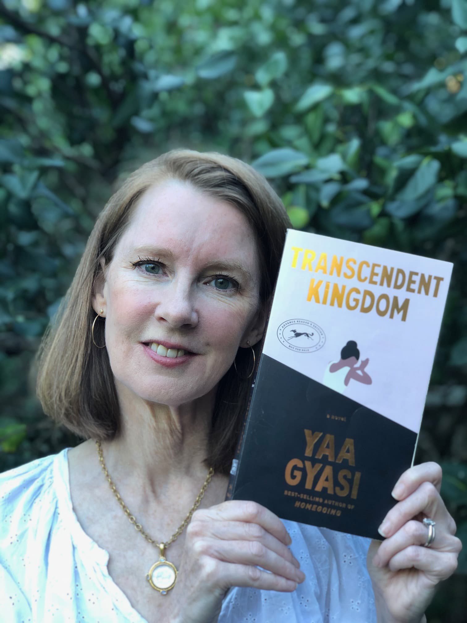 Gretchen holding the Transcendent Kingdom book cover