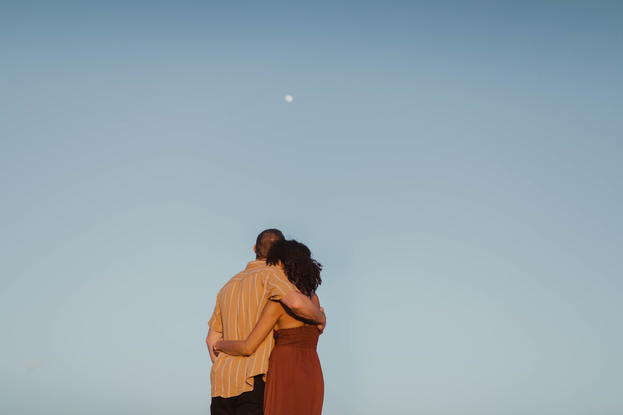 Two people hugging while watching the sky