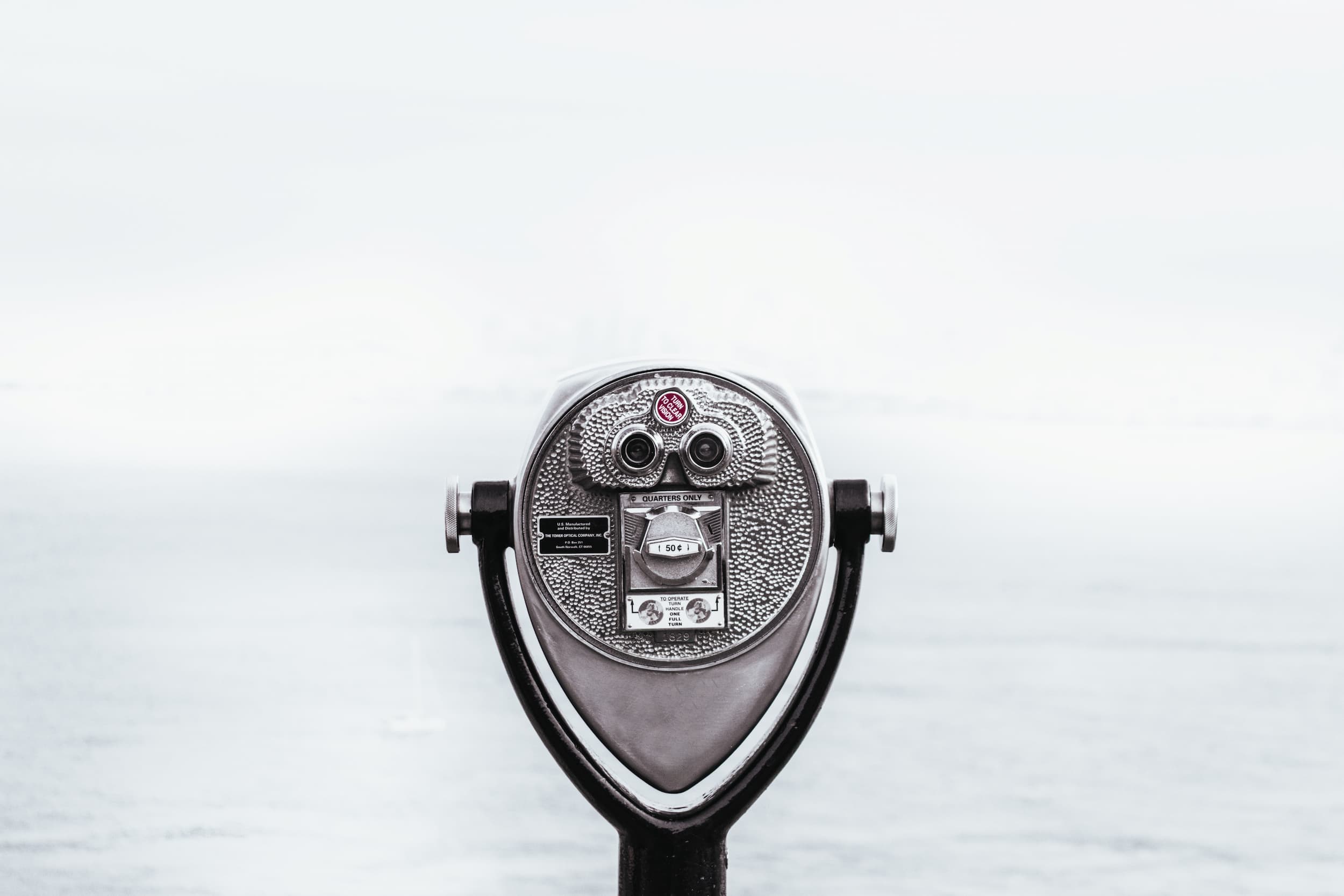 Photo of coin-operated binoculars in front of foggy ocean scape.