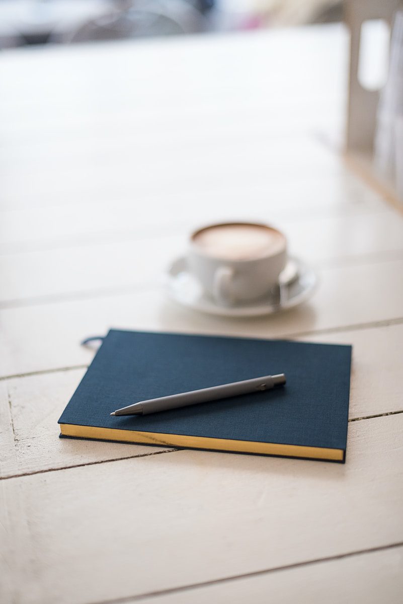Notebook with pen and coffee cup