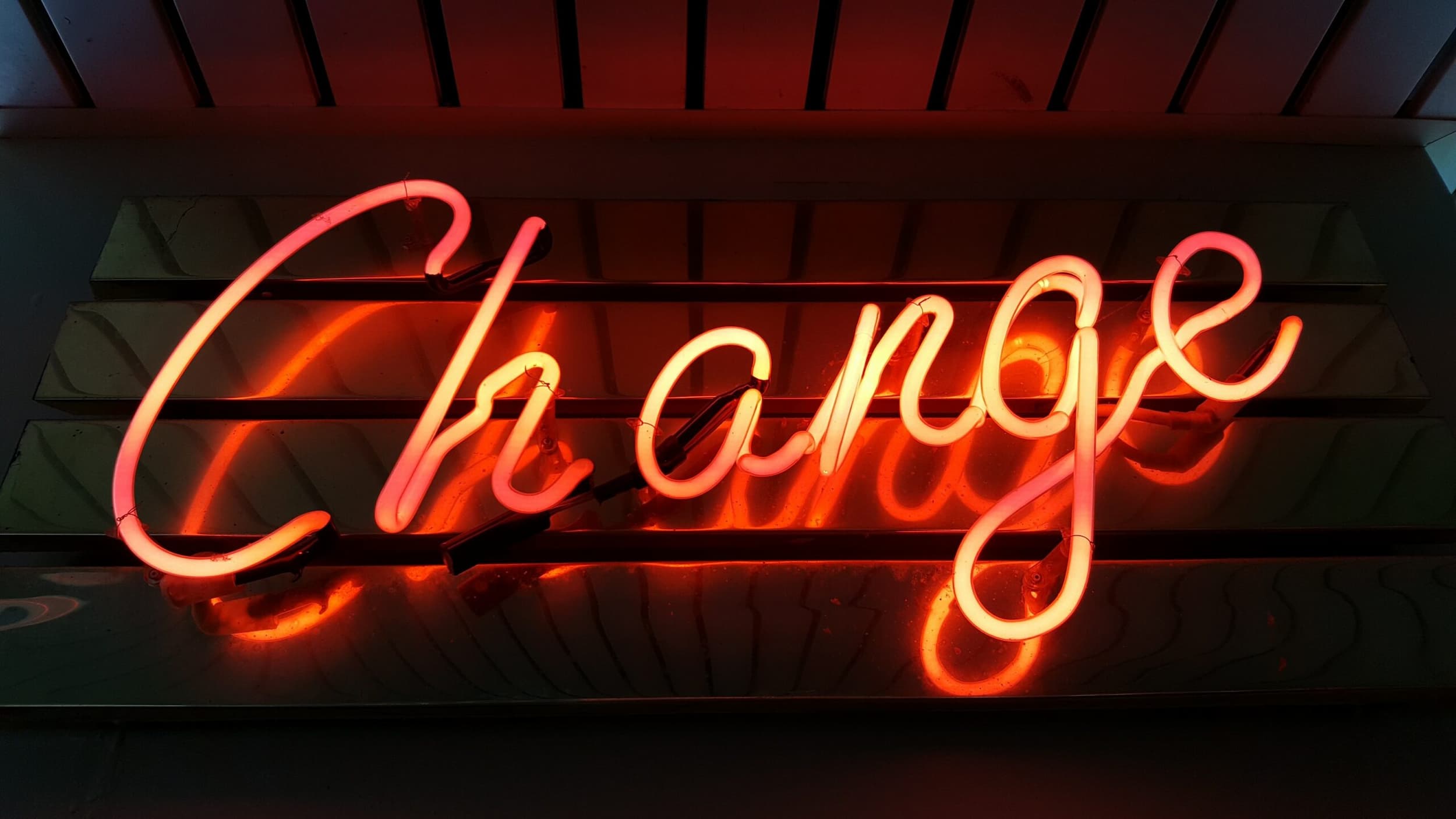 Photo of a neon sign in the shaped of the word Change