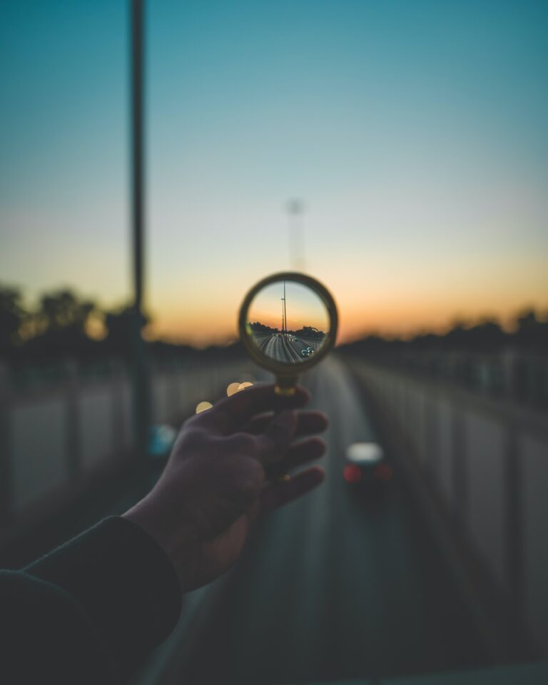 Photo of a person holding up a magnifying glass