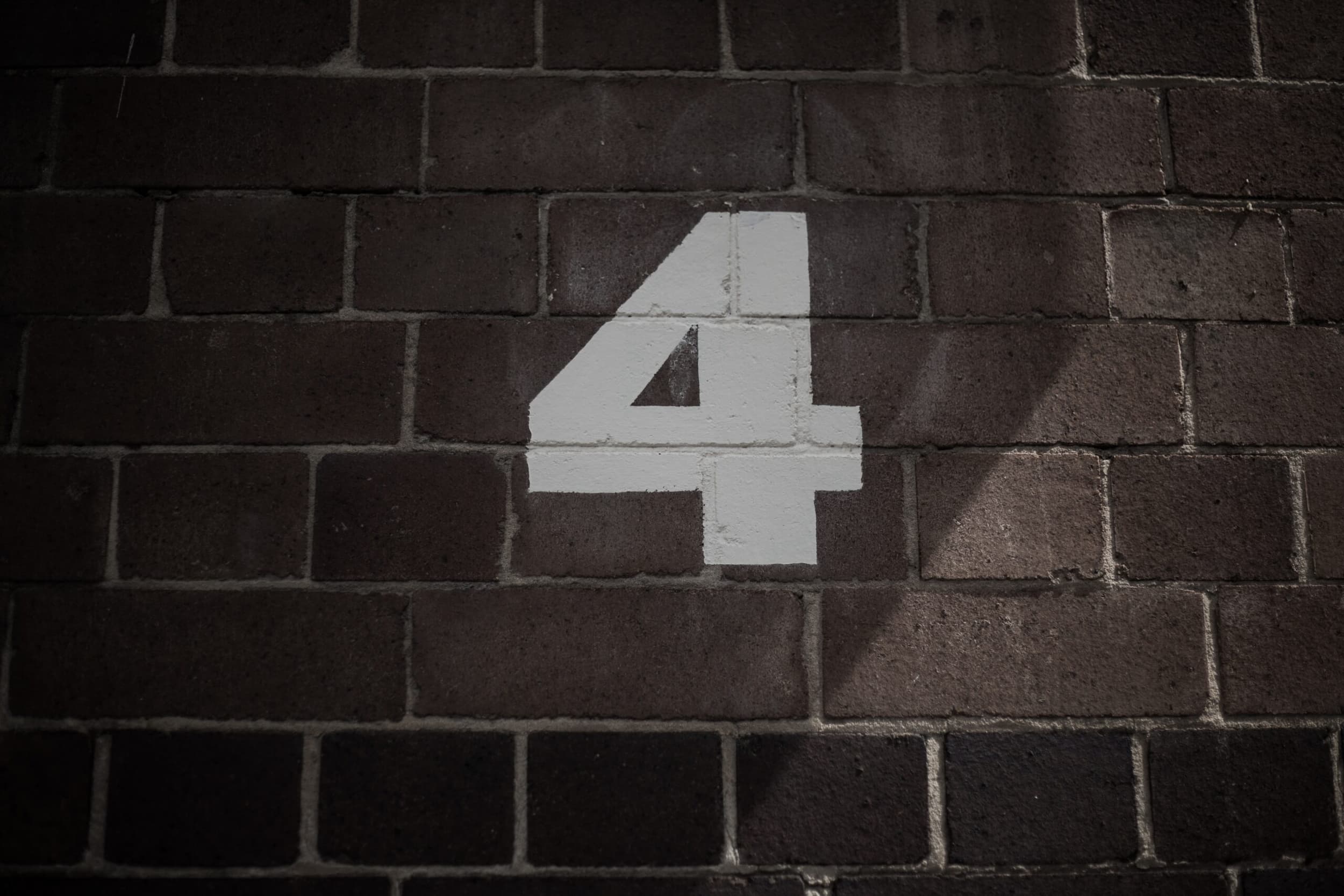 Photo of number 4 painting on a brick wall