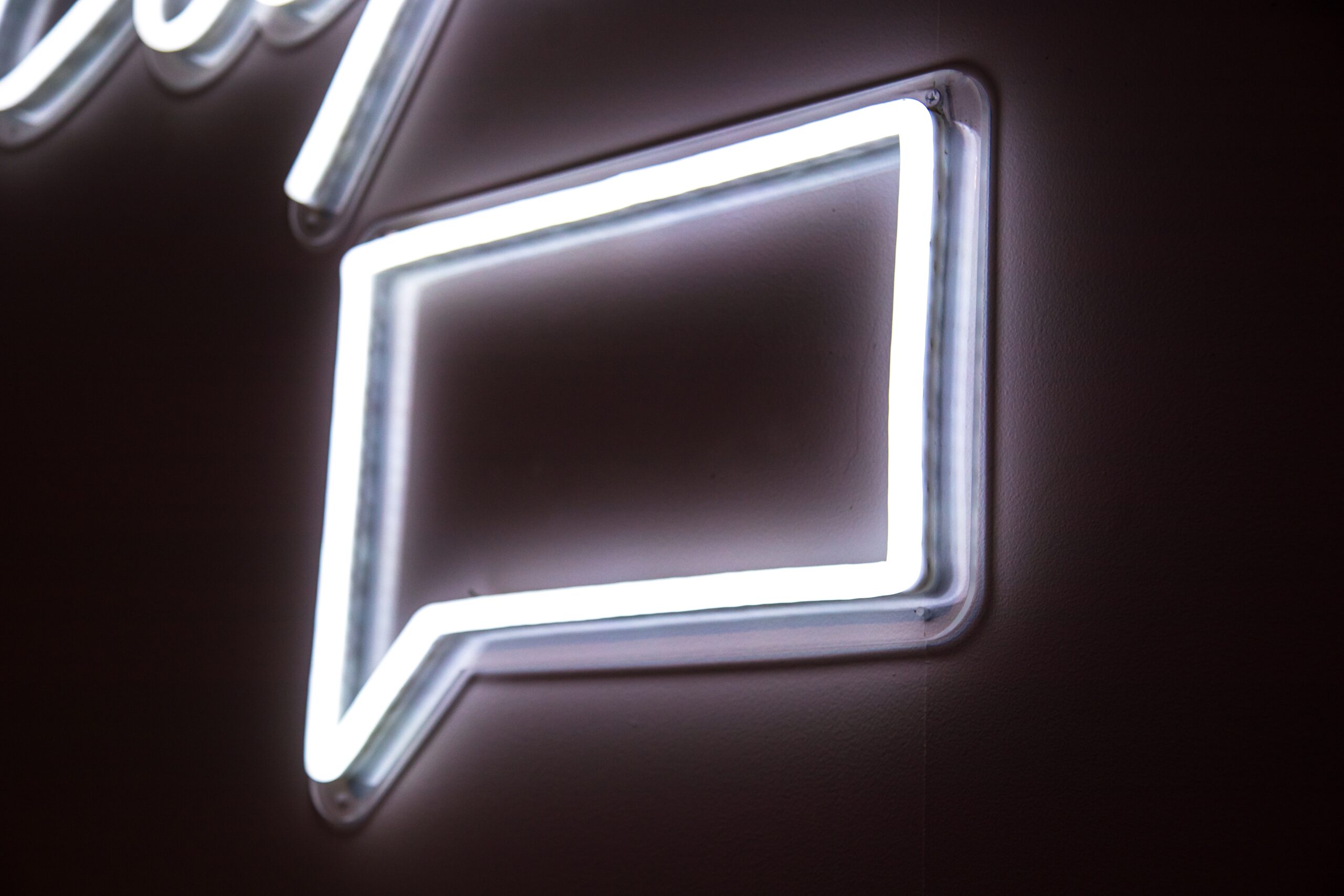 Photo of a neon sign shaped with a speech bubble