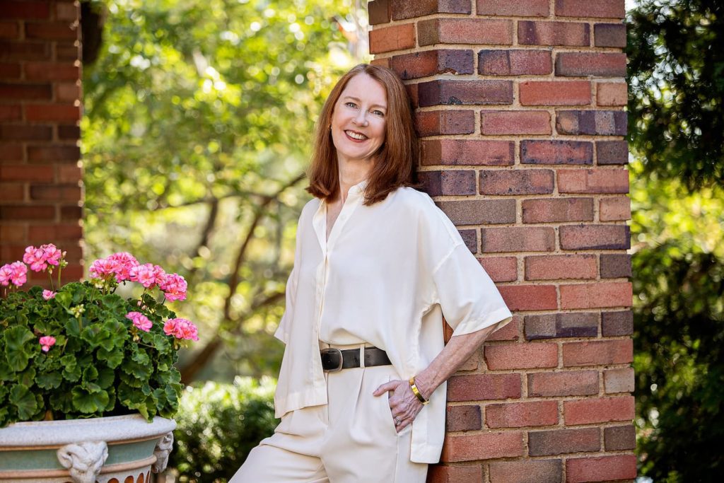 Gretchen in garden against brick column