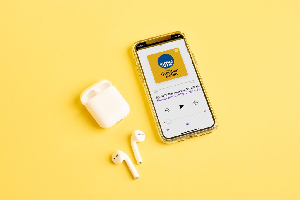 Podcast on iPhone with earphones yellow background