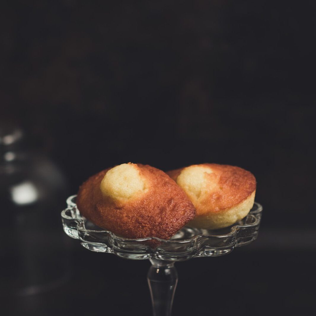 two baked breads placed on clear glass cupcake stand in focus photography