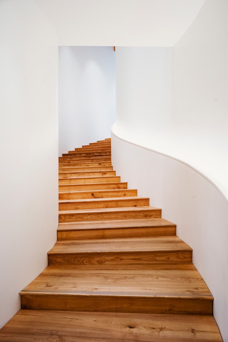 A set of wooden stairs leading up to a white wall