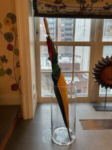 An umbrella in a large glass vase