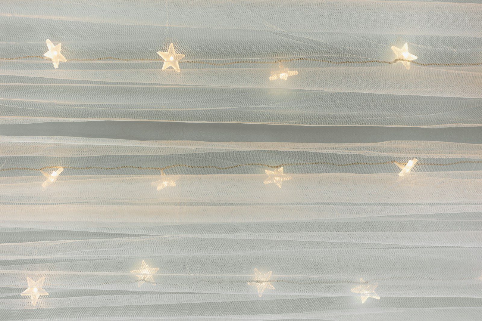 Fairy lights shaped like stars on a white background.