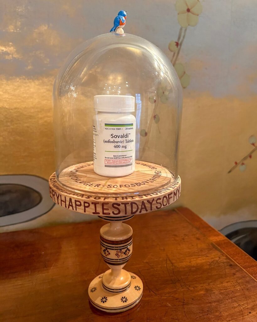 A medication bottle under a glass cover, labeled "happiest day"