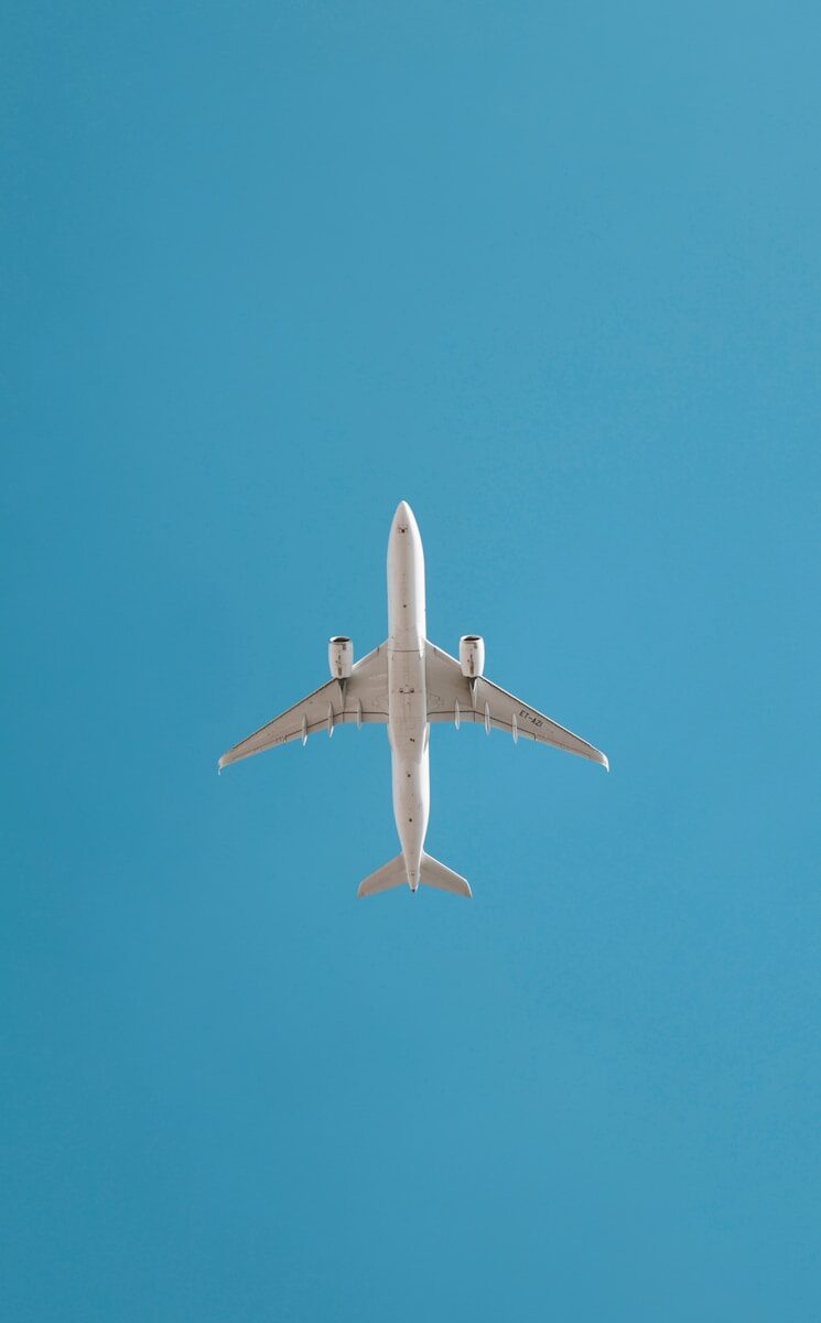An airplane soars in the blue sky.