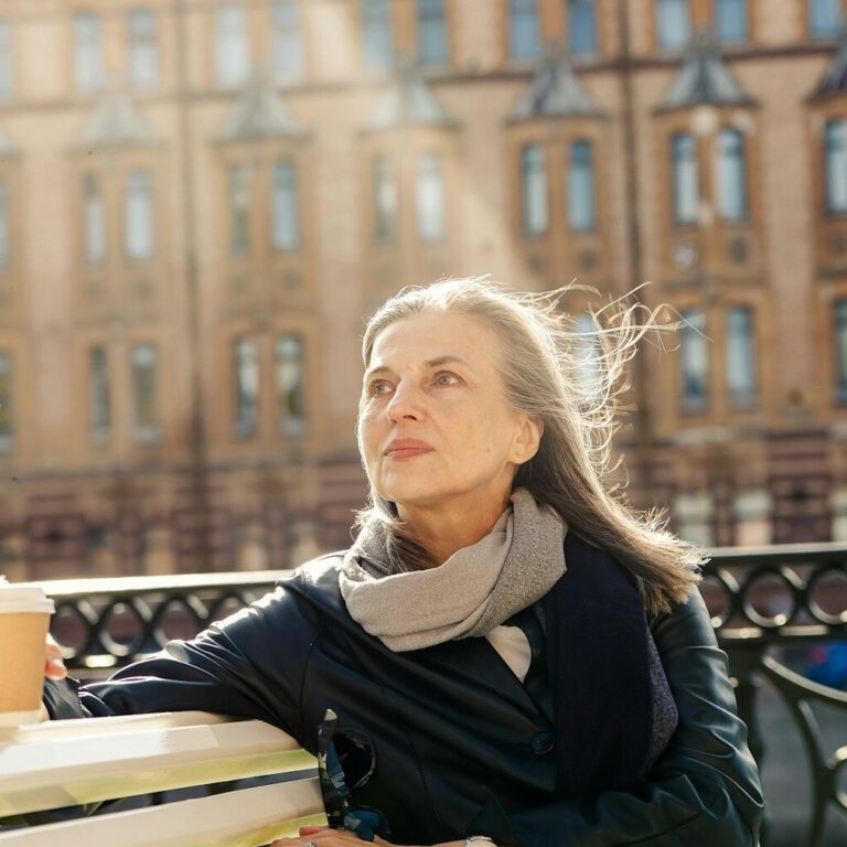 a woman sitting at a table outside