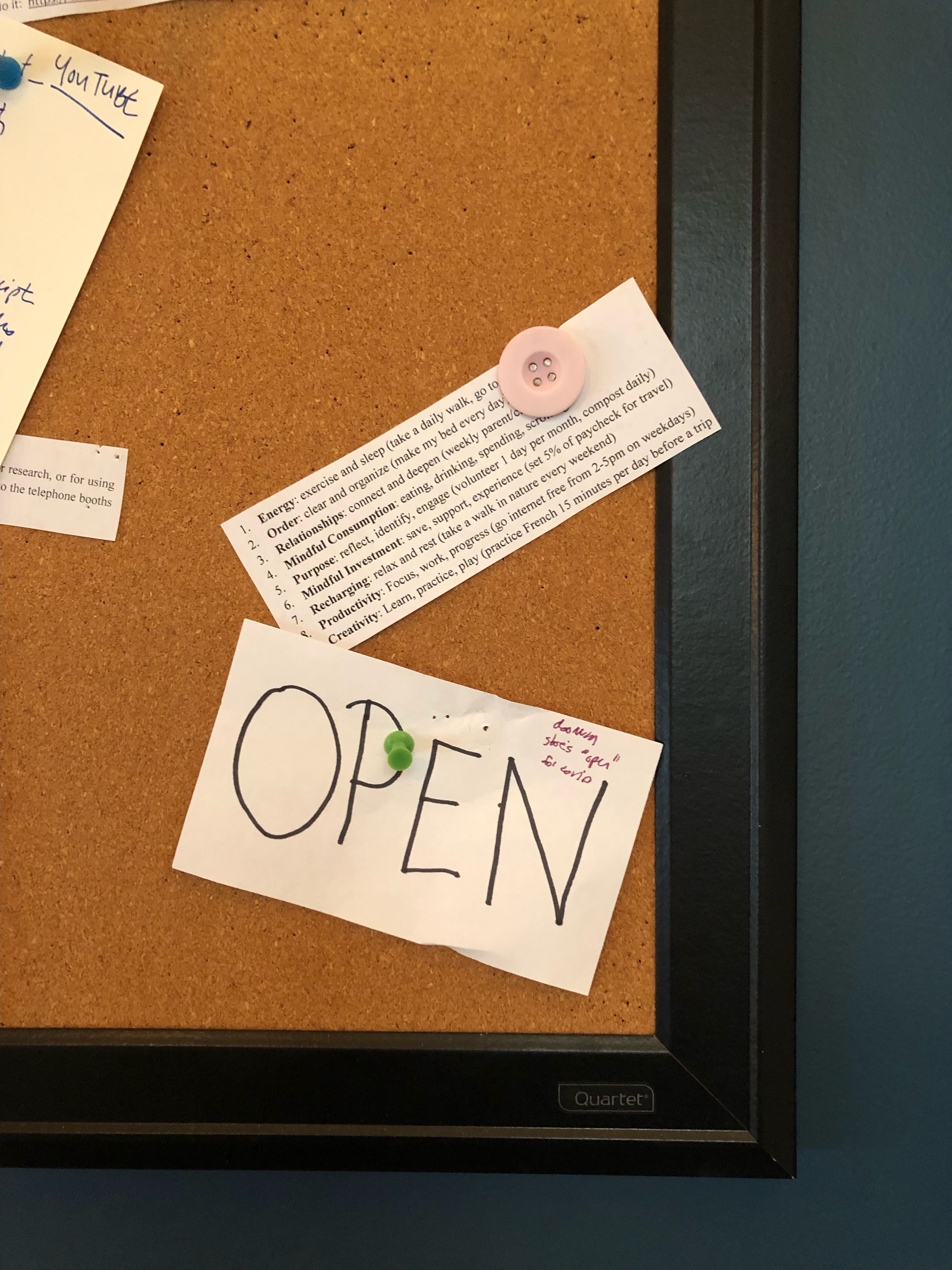 Gretchen's cork board with the word "open" on an index card